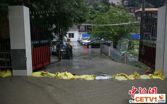 民众使用沙袋堵住洪水，避免流向民房。　德格轩 摄